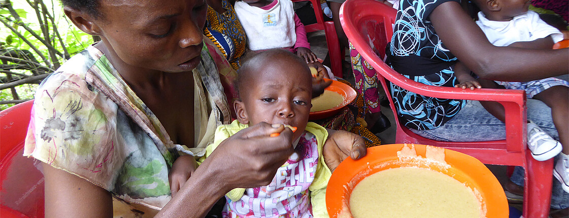 Mütter sitzen mit ihren Babys in einer Ernährungsstation in Kinshasa, DR Kongo, wo sie Nahrungshilfe und Unterstützung erhalten.