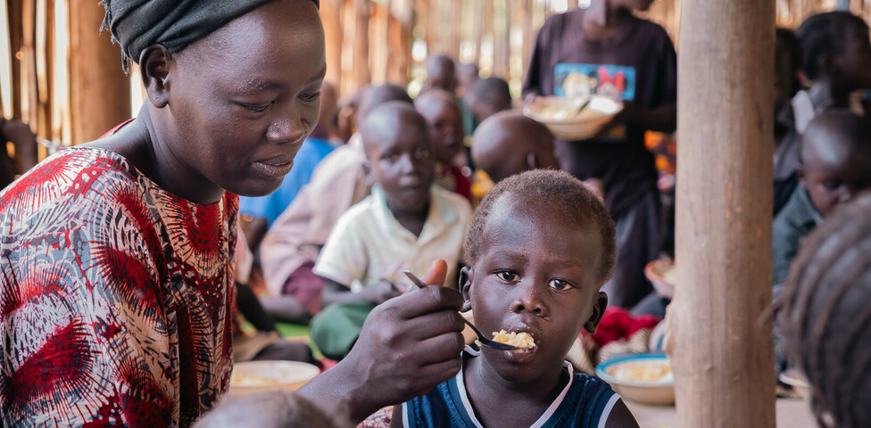 Eine Betreuerin füttert ein Kind in einem Ernährungszentrum im Südsudan.